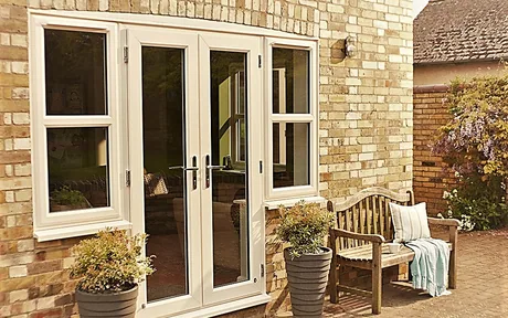 White French swing doors with sidelites on a brick home exterior