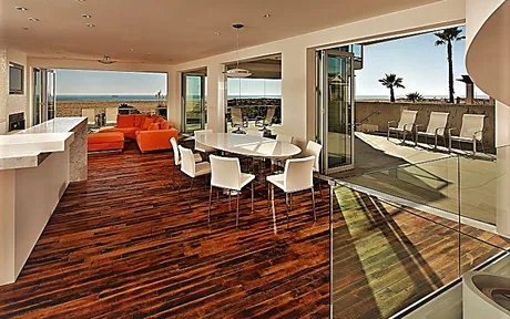 Multi-slide glass wall opened from a dining room onto an ocean-view deck