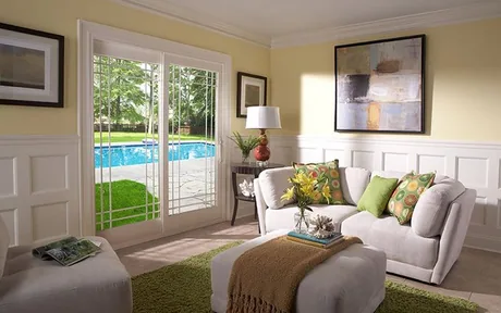 Living room window looking onto a pool, framed in white vinyl